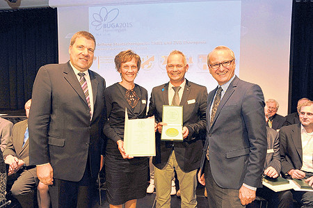 Einen Staatsehrenpreis in Gold für ihre Hallengestaltungen nahmen Odette und Bert von der Forst aus Cottbus-Gallinchen entgegen, hier beglückwünscht von Andreas Lohss (l.), Vizepräsident des Zentralverbandes Gartenbau, und Clemens Neumann (r.), Staatssekretär im Ministerium für Ernährung und Landwirtschaft. Einen Ehrenpreis in Bronze erhielt der Kolkwitzer Gartenbaubetrieb Borchel für seine hervorragenden HeidekulturenFoto: Thomas Uhlemann