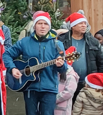 Mit der Gitarre gab Michael Rabes, der sich auch als CDU-Stadtverodneter für Ströbitzet Interessen einsetzt, den richtigen Ton des REWE-Advent- singens an. Der Familienvater hat selbst auch schon Erfahrung als dinsthabender Mann im roten Mantel zur Bescherung. 