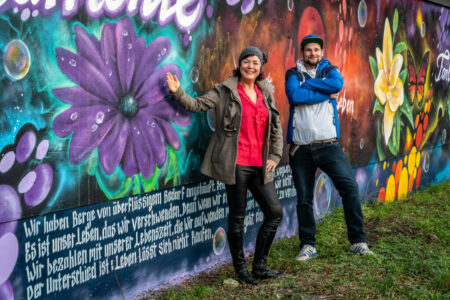 Mandy Sprejz und Martin Jainz präsentieren die neu gestaltete Garagenwand in der Ackerstraße in Cottbus