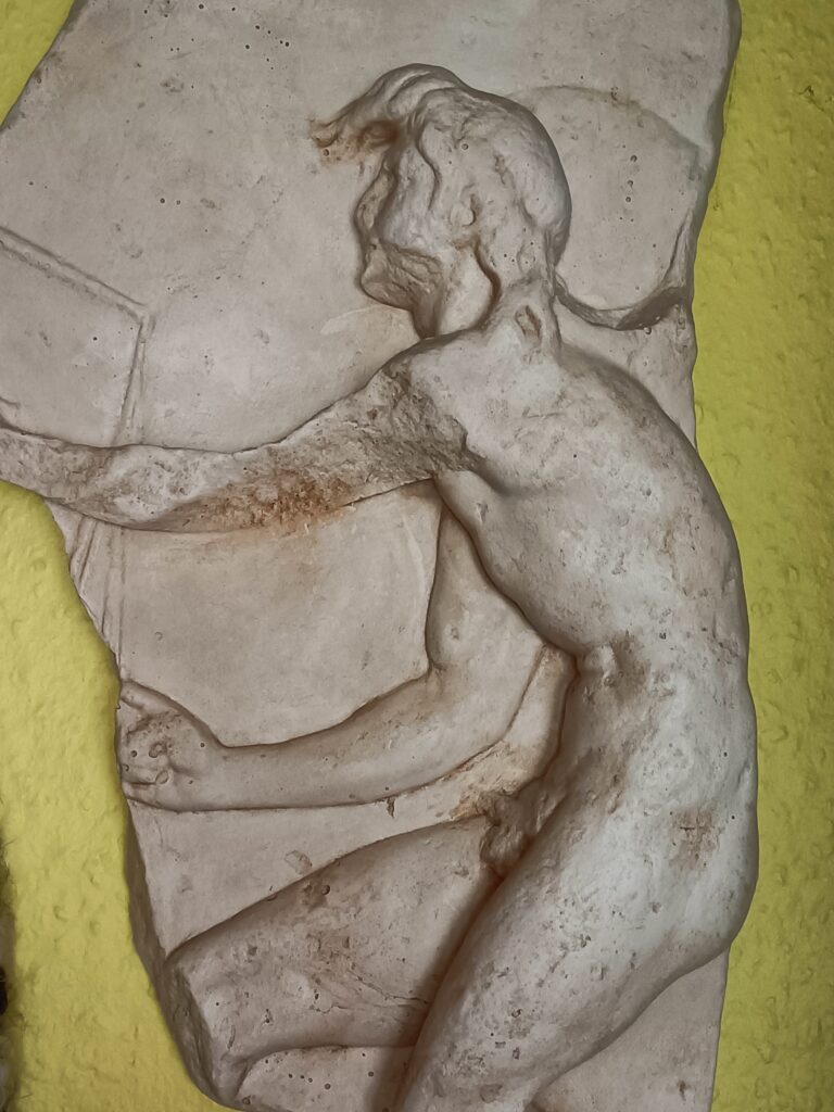 KAIROS-Relief aus dem 3. Jh. v.Chr. in der Kunstsammlung im Kloster St. Nikolaus im kroatischen Trogir. Markant sind der kahle Hinterkopf und der bauschige Schopf nach vorn. Die geflügelten Füße des schnellen jungen Gottes sind leider nicht erhalten.