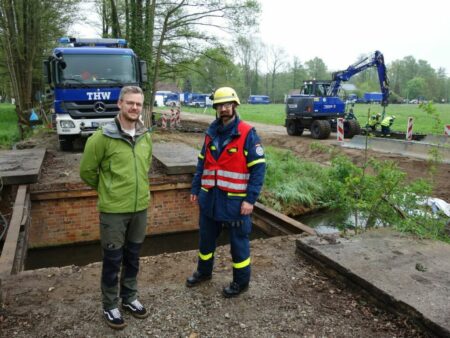 Matthias Koal und THW-Einsatzleiter Maximilian Beyer (v. l.) an der bereits zurück gebauten Brücke am Stillen Fließ. 