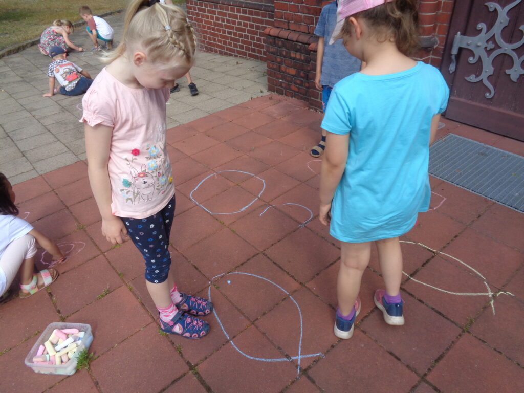 Die Kinder der Kita St. Martin probierten sich selbst im Malen des christlichen Geheimzeichens aus.