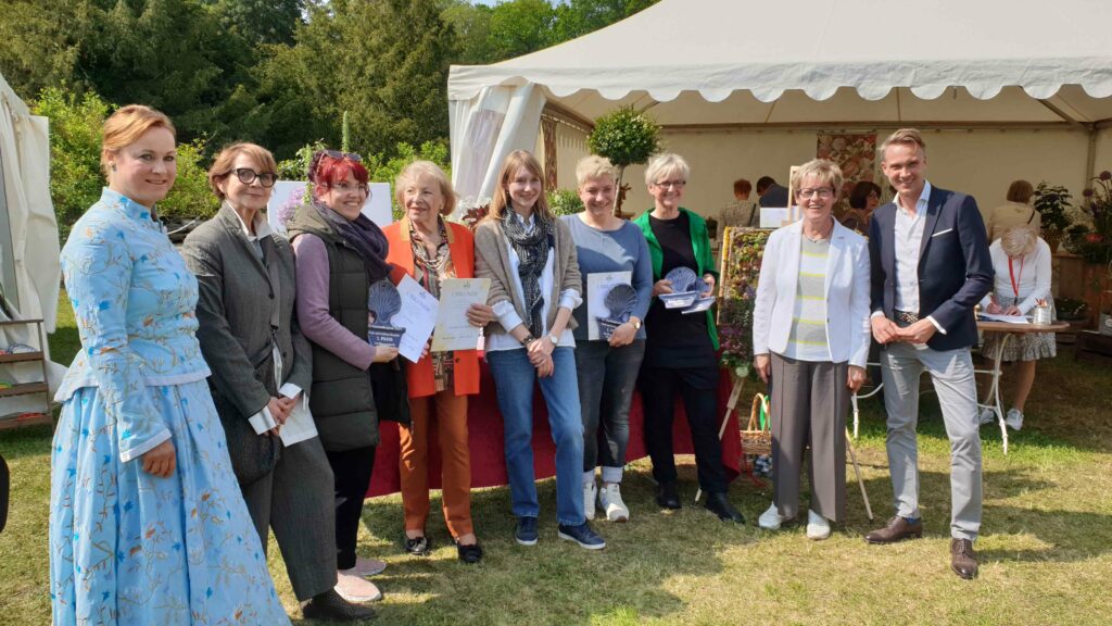 Große Freude am Ende des Blumensteck-Wettbewerbes bei allen Beteiligten und Geehrten (v.l.n.r.): Moderatorin Anne Schierack, Bürgermeisterin Marietta Tzschoppe, Doreen Kosel (2. Preis), Gräfin Elke von Pückler als Schirmherrin, Doreen Goethe für das veranstaltende Unternehmen pool production, Christiane Lehmann (1.Preis), Martina Schulz (3.Preis und Kreativpreis), Organisatorin Waltraud Ullrich vom Verein Fürst Pückler in Branitz und Stiftungsdirektor Dr. Stefan Körner.