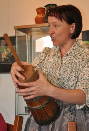 Museumsmitarbeiterin Melanie Mücksch erläutert das Buttern zu (Ur-)Omas Zeiten. 