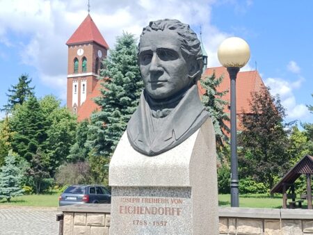 Eichendorff-Büste vor dem Hintergrund der neuen Kirche.