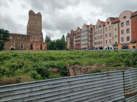 Nowa Sól. Vorn noch eingeebnete Altstadt, dahinter die Ruine der St. Nikolaus Kirche, rechts die Neubauten.