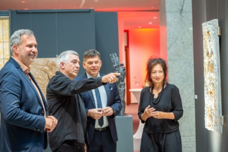 Hans-Georg Wagner (2.v.l.) führt Ralf Braun (M.), Vorstandsvorsitzender der Sparkasse Spree-Neiße, Oberbürgermeister Tobias Schick (l.) und Ulrike Kremeier, Direktorin des Brandenburgischen Landesmuseum (BMLK) durch die neue Ausstellung und erläutert seine Kunstwerke