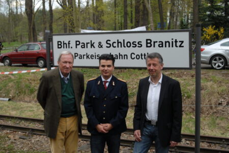 Kurz nachdem das Ausflugslokal, das schon seit Juni 1995 geschlossen war, abgerissen wurde, bekam die Parkbahn-Endstation im Mai 2011 einen neuen Namen. Im Bild v.l.: Herrmann Graf Pückler (1939-2017), der schon als Kind mit dem späteren „Friedenseiche“-Wirt Hans Rätzel befreundet war, Denis Kettlitz, damals Vorsitzender des Parkbahn-Fördervereins, heute Chef des OB-Büros, und Jörg Reinke, bis 2014 Geschäftsführer von Cottbusverkehr, Betreiber der beliebten Parkeisenbahn.