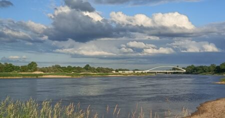 Blick auf die Oder vom Küstriner Ortsteil Kuhbrücke. Von rechts kommt der Vorfluter zum Fluss mit jetzt breitem Sandstrand, hinten die Brücke nach Polen.